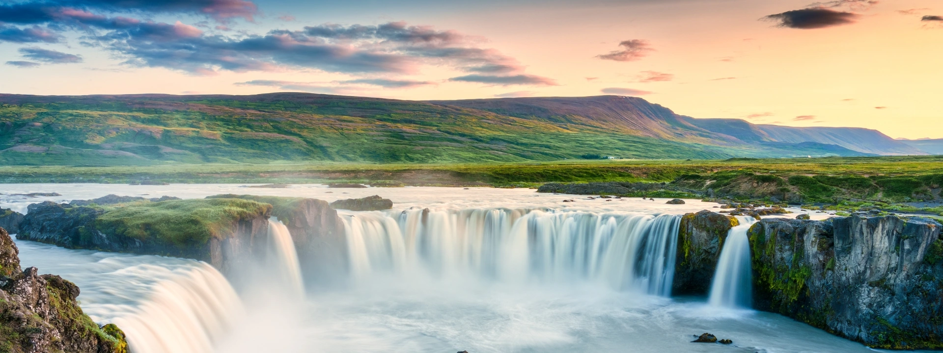 Iceland - Godafoss waterfall flowing with colorful sunset sky in summer at Iceland